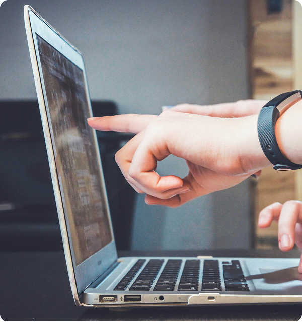 Image of laptop and hand pointing at the screen